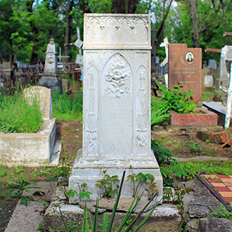 Белое надгробие напротив внешней иконы на церкви